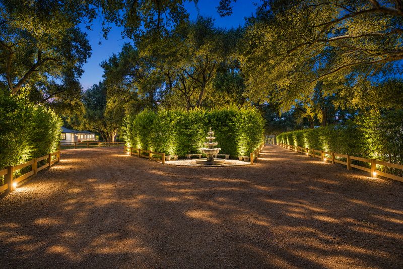 The entry drive and fountain lit at dusk